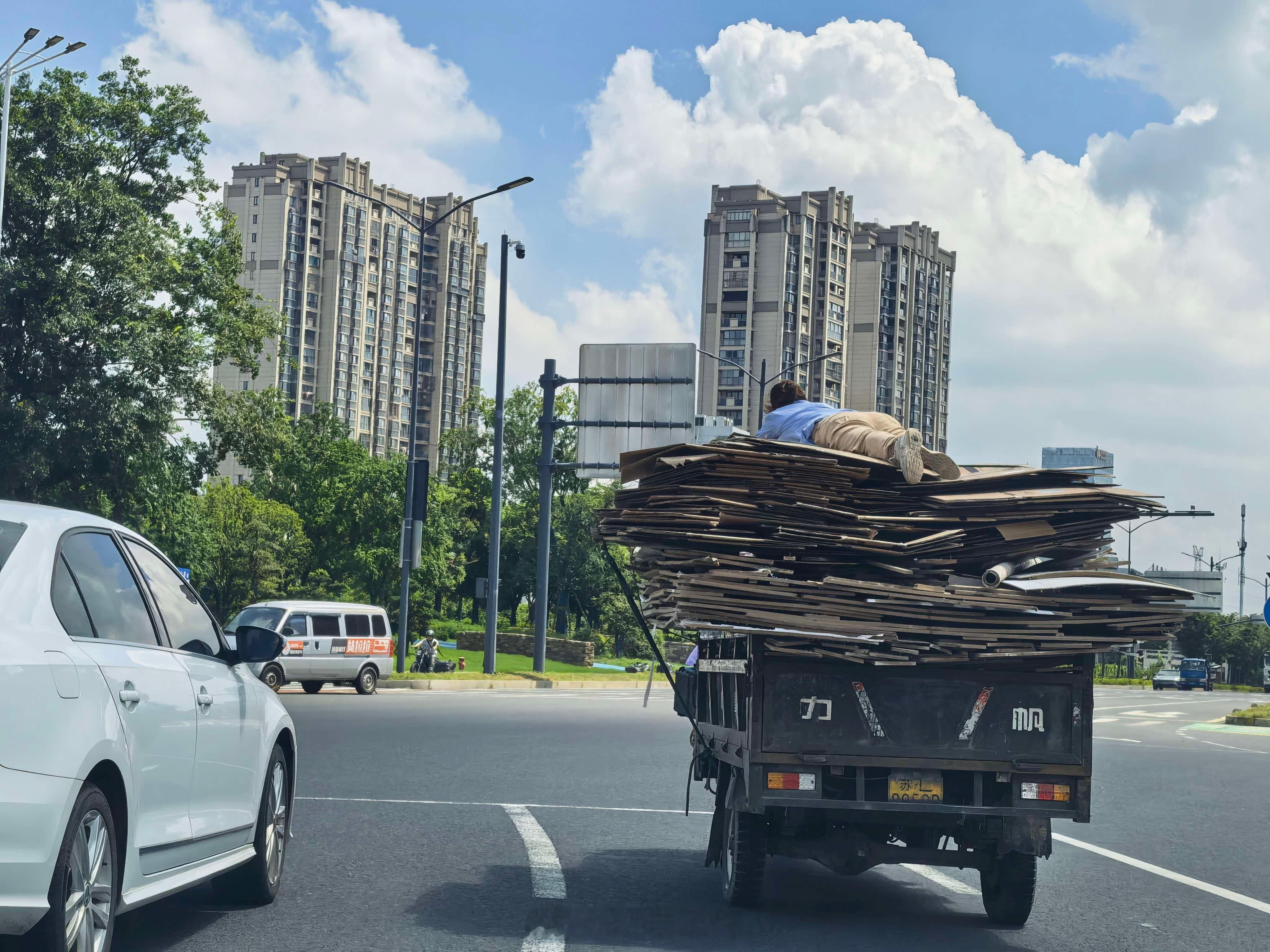 这是在干嘛……用人的重量来压住纸板吗？这安全意识是不是太薄弱了一些新能源汽车﻿﻿