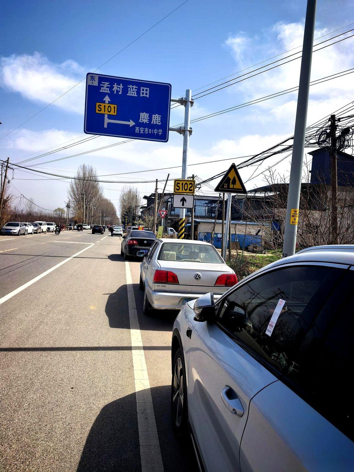 好家伙，我直接一个好家伙。两公里，乌泱乌泱上千辆车，整整齐齐地停在水安路边上。