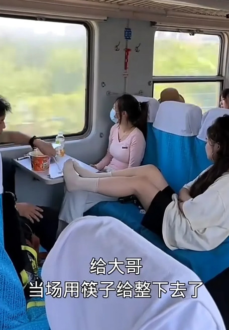 普通火车上，男人正泡了一碗方便面，准备吃饭。这时对面的小姑娘可能睡糊涂了，为