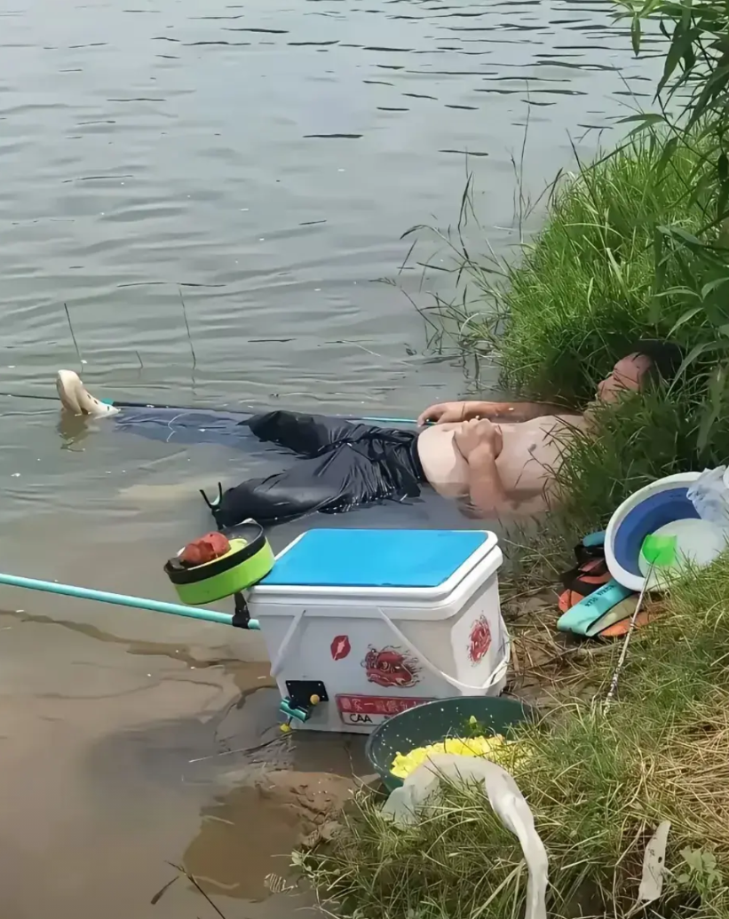 40度高温下，男子钓鱼钓得头晕脑胀，不顾危险躺水里休息。这地方睡着翻身便可能溺亡