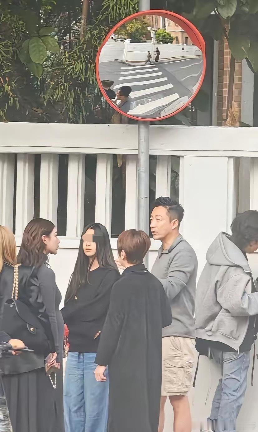 马筱梅挺着大肚子陪一家人游玩，走到街道拿出手机拍照，走到路口，一家人驻足讨论，小