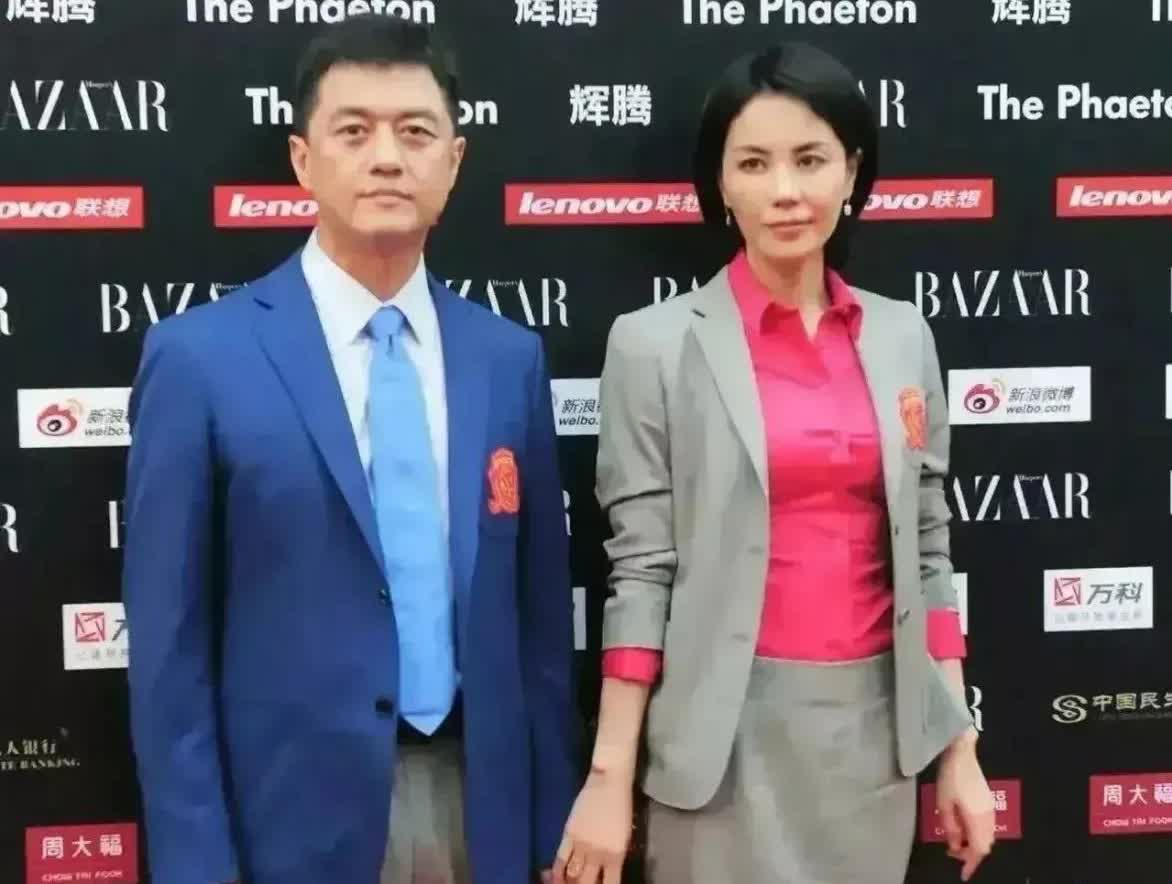 照片中，王菲把手靠近李亚鹏，希望他牵她的手，李亚鹏却没有，而是自顾自地站着无视了