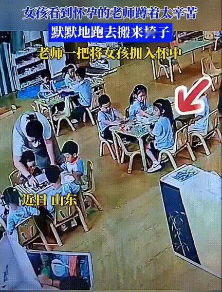 “太贴心了！”，山东，一幼儿园，老师正领着孩子们做手工，小朋友的桌子很矮，怀孕的