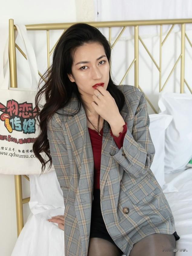 脱下长靴，换上舒适的黑色短裤，慵懒地坐在柔软的粉色地毯上，展现出截然不同的松弛感