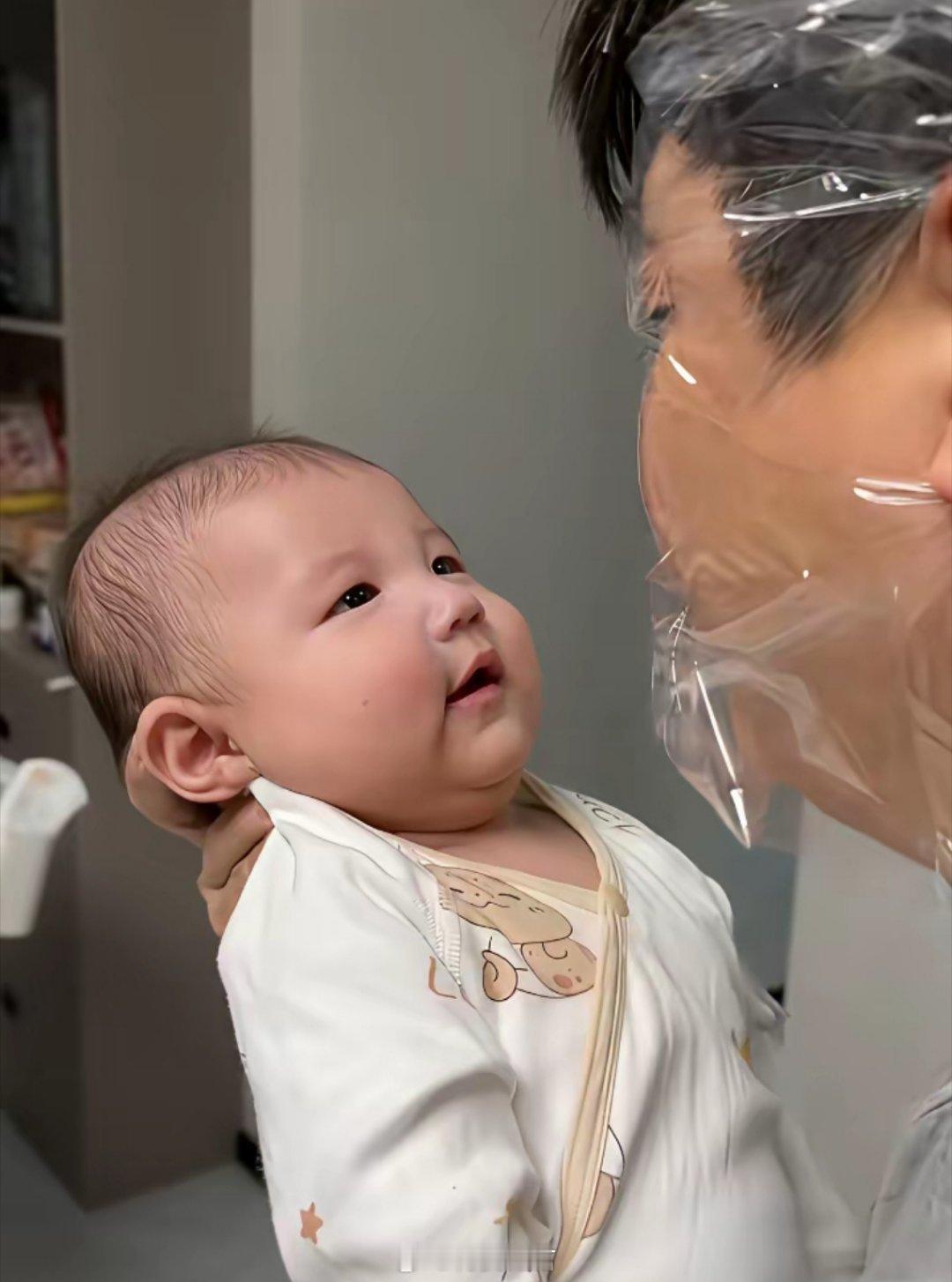 宝宝被爸爸捧在手心，脸上轻蒙一层软膜，爸爸便凑上去亲了又亲——这下可过足亲子瘾了