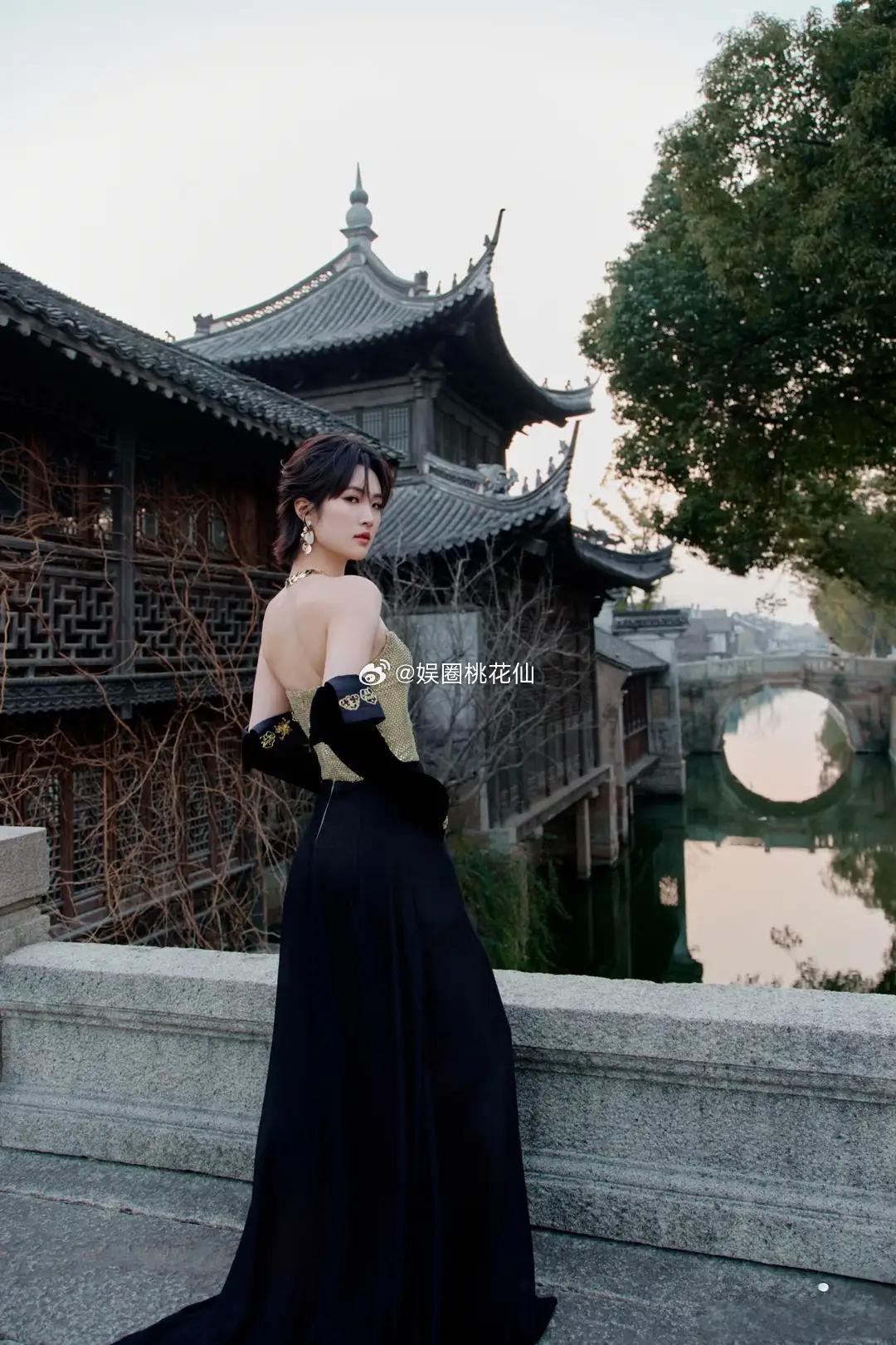 姚安娜身着露肩长裙，黑丝绒手套衬得肌肤胜雪，立于桥上，复古韵味交织着精致美感，风