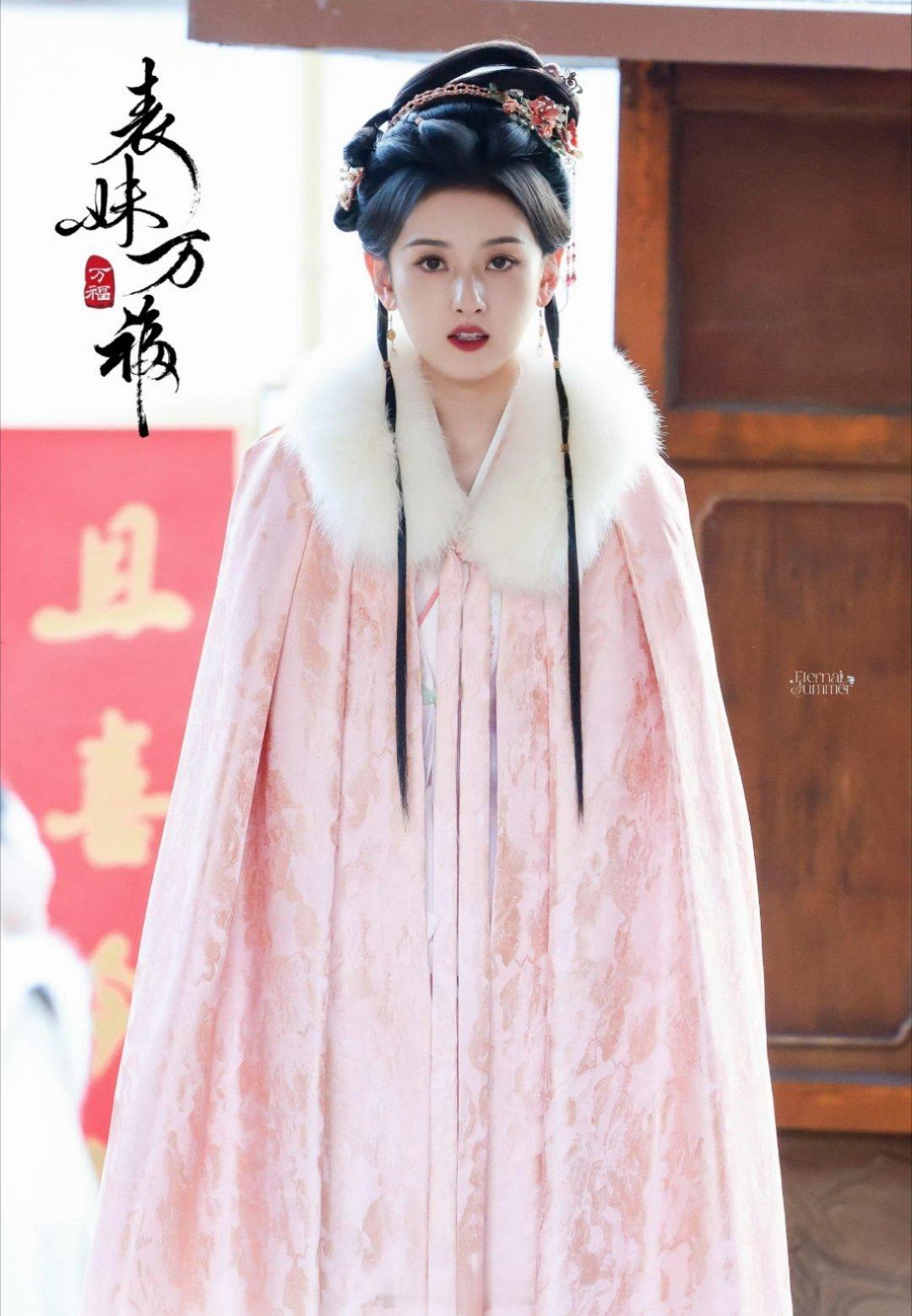 宋祖儿主演的《表妹万福》最新妆造，一身粉红色内搭配上粉色系大斗篷，宋祖儿一脸无辜