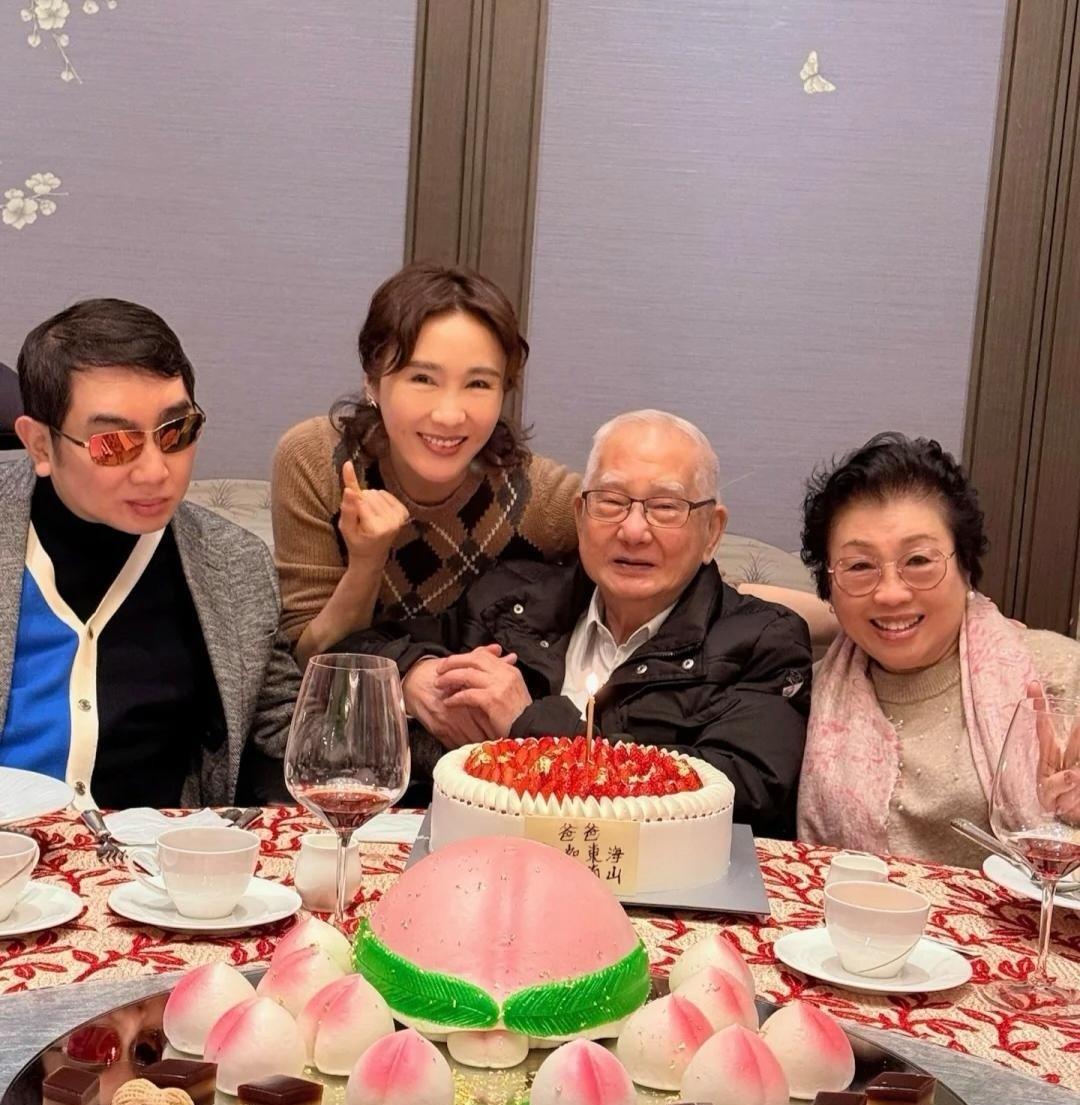 黎姿在酒店为父亲庆祝88岁生日，妈妈、弟弟黎婴都在场，桌上摆着蛋糕和寿桃，看起来