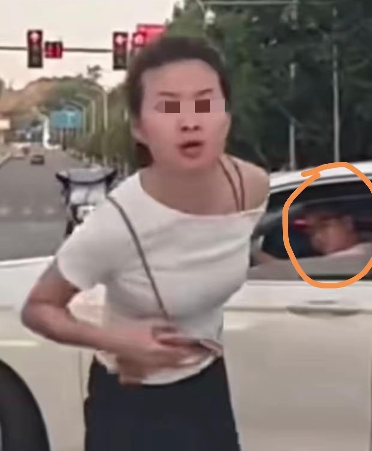 这个就是“人肉拦车加塞”的女子，双手叉腰站在机动车道，一副很凶的样子，非但不感谢