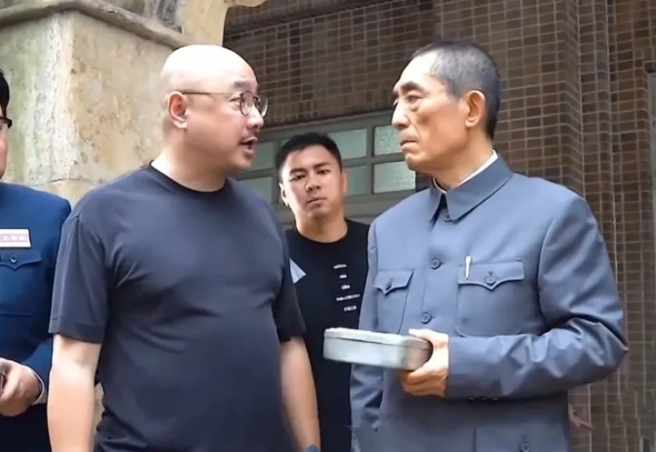 演员导演徐峥给知名导张艺谋说戏！穿中山装的张艺谋认真的听导演徐峥指导，一脸的认真