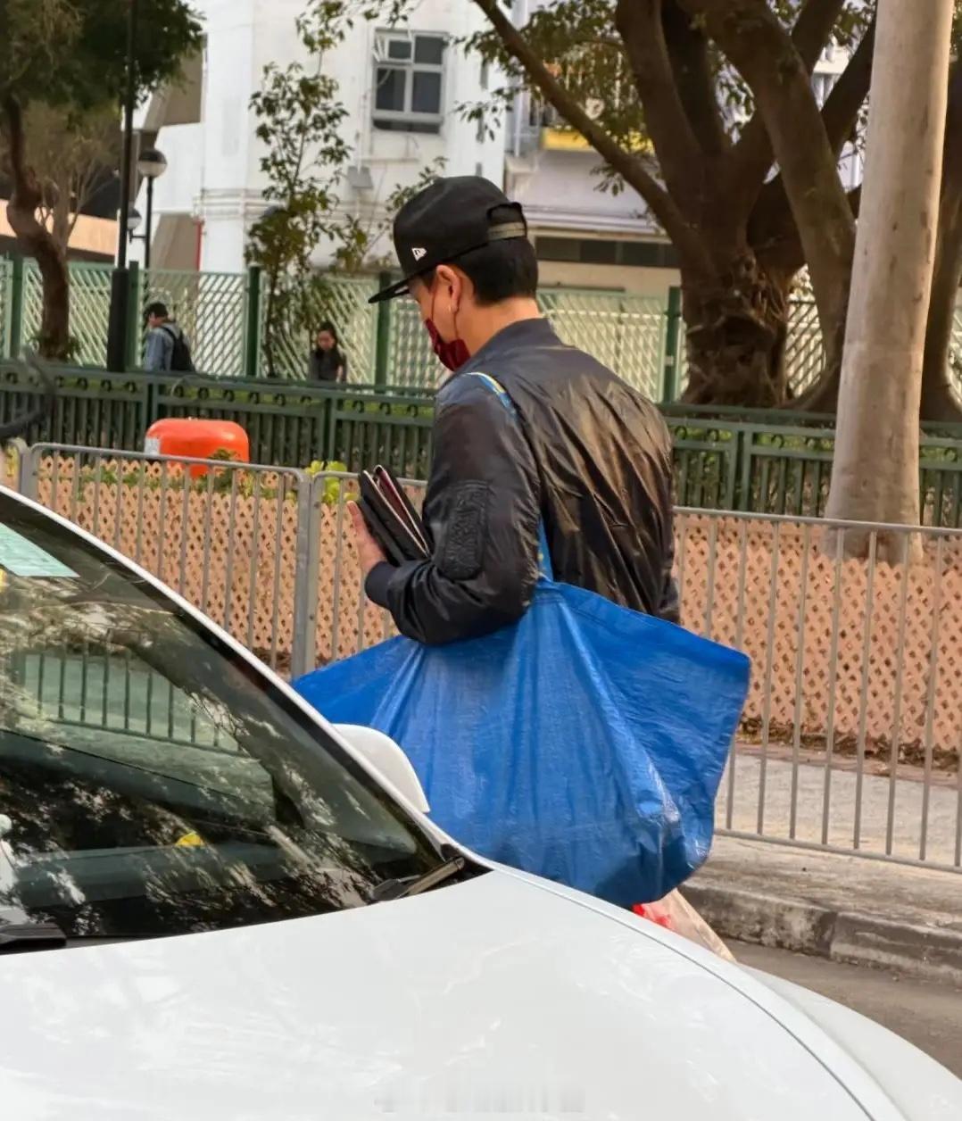 黄宗泽现身香港菜市场买菜，他素颜现身，打扮低调，他背着蓝色大蛇皮袋，一手还拎着方