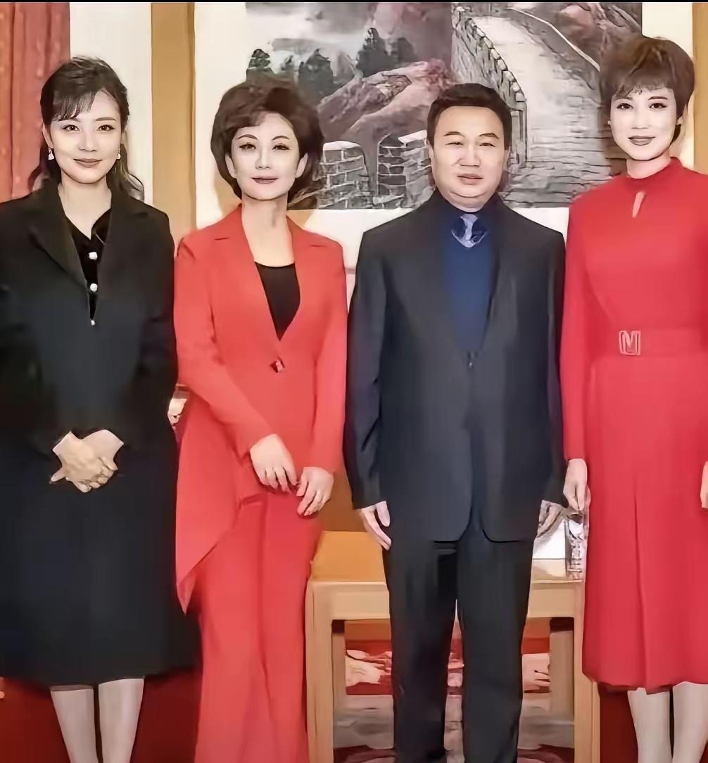 左边身穿黑色衣服，俩手放到前面的是最美主持人周涛。左二身橘红色裙子，笑容甜美，和
