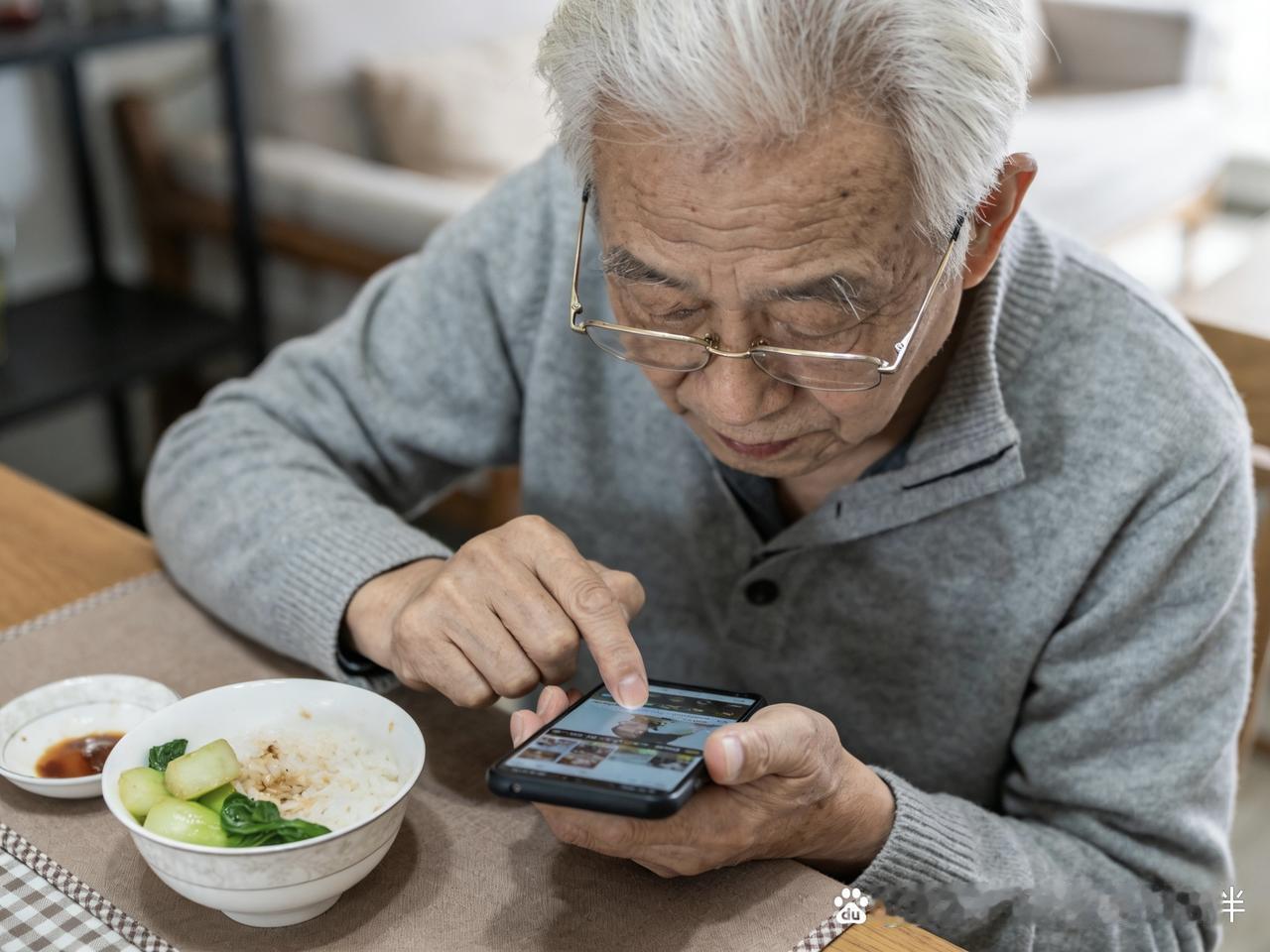 楼下王大爷最近成了“手机控”，大清早就在花坛边蹲着刷短视频，吃饭时手机架在桌上，