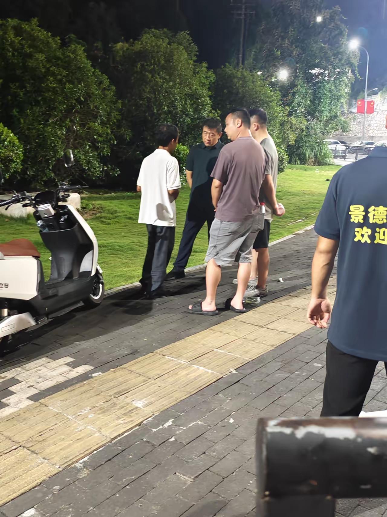 这是网友在景德镇拍到的，疑似鸡排哥在跟工作人员交流，汇报情况。鸡排哥站得笔直，望