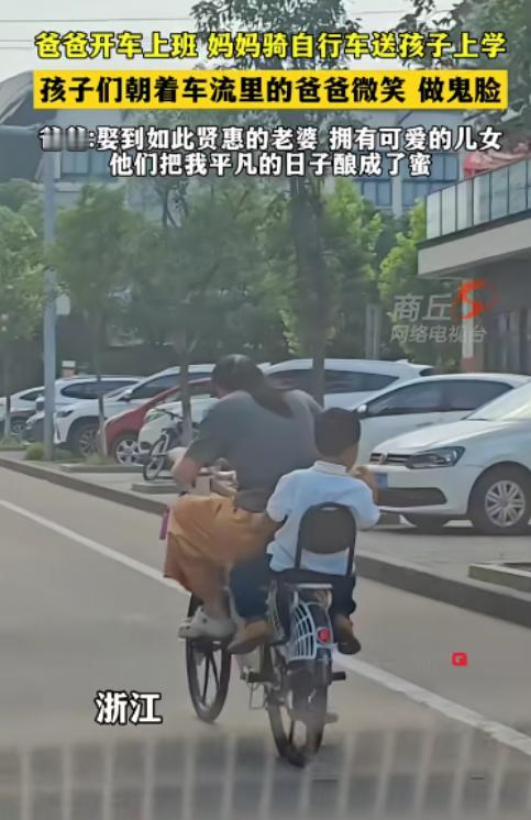爸爸开车上班，妈妈骑自行车送孩子上学，孩子们朝着车流里的爸爸微笑、做鬼脸。
