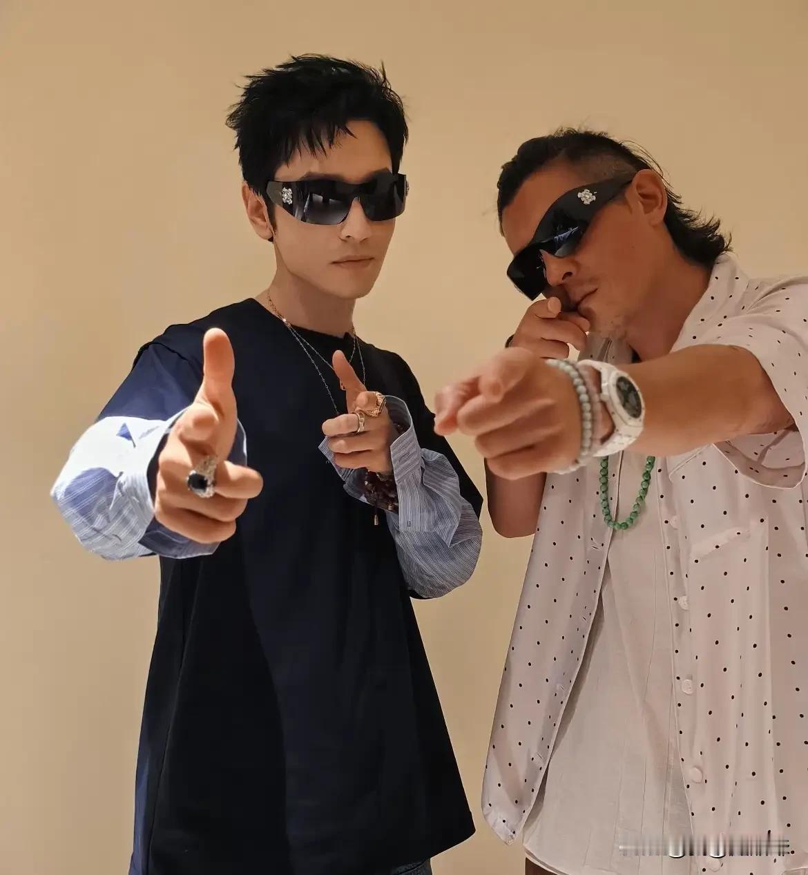 现在的晓明哥也让我们看不懂了，T恤里面穿衬衣，脖子上大金链子套小金链子，左右双手