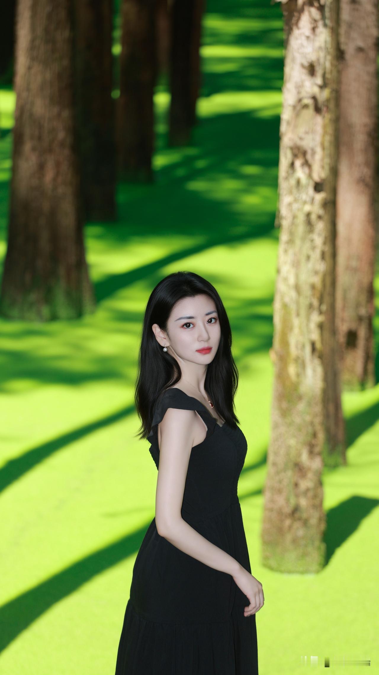 黑裙少女漫步在绿意盎然的森林中，静谧而优雅。