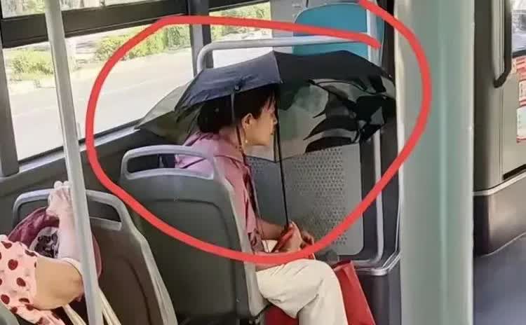 广东，一名女子在乘坐公交车的时候，突然发现一位阿姨在上了车之后，立马把手中的遮阳