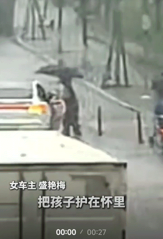 浙江义乌一街头，狂风暴雨突至，期间一女子驾车驶过一路口时，便看到一位老人带着孙子