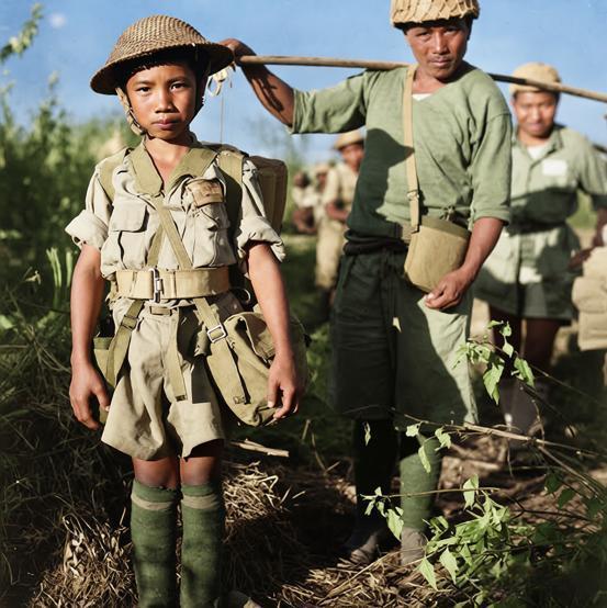 抗日战争时期，一位中国少年士兵（俗称“娃娃兵”），身着军服、佩戴装备，站在野外环