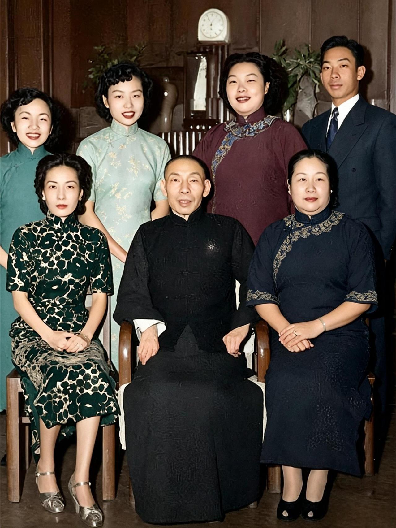 照片里，穿黑色长衫的男人端坐在正中，面容清瘦，嘴角抿着一点笑意，袖口露出雪白衬里