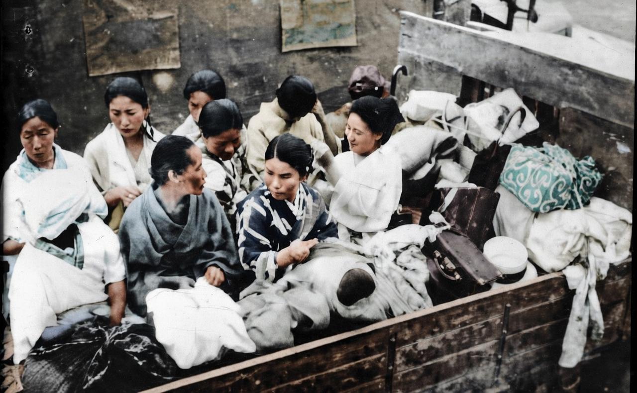 1942年，包头，一辆军用卡车的车厢里挤满了多名女性，她们身边堆放着简单的行李，