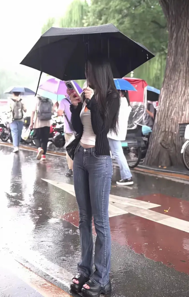 雨天街头偶遇伞下小姐姐！专注看手机，猜猜她在等谁的消息？