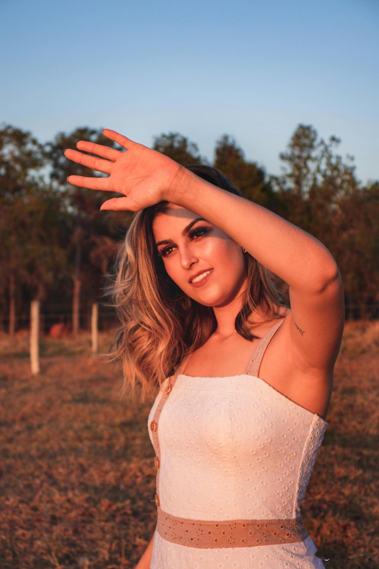 阳光下的美女，微笑着挥手。