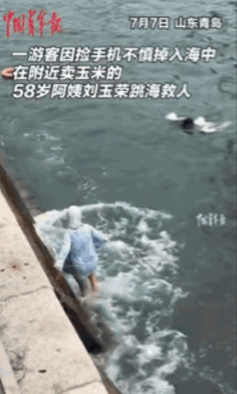 “这位大妈火了！”青岛海边，一女生拍照时手机不小心掉进海里，女子只想着捞手机却忘