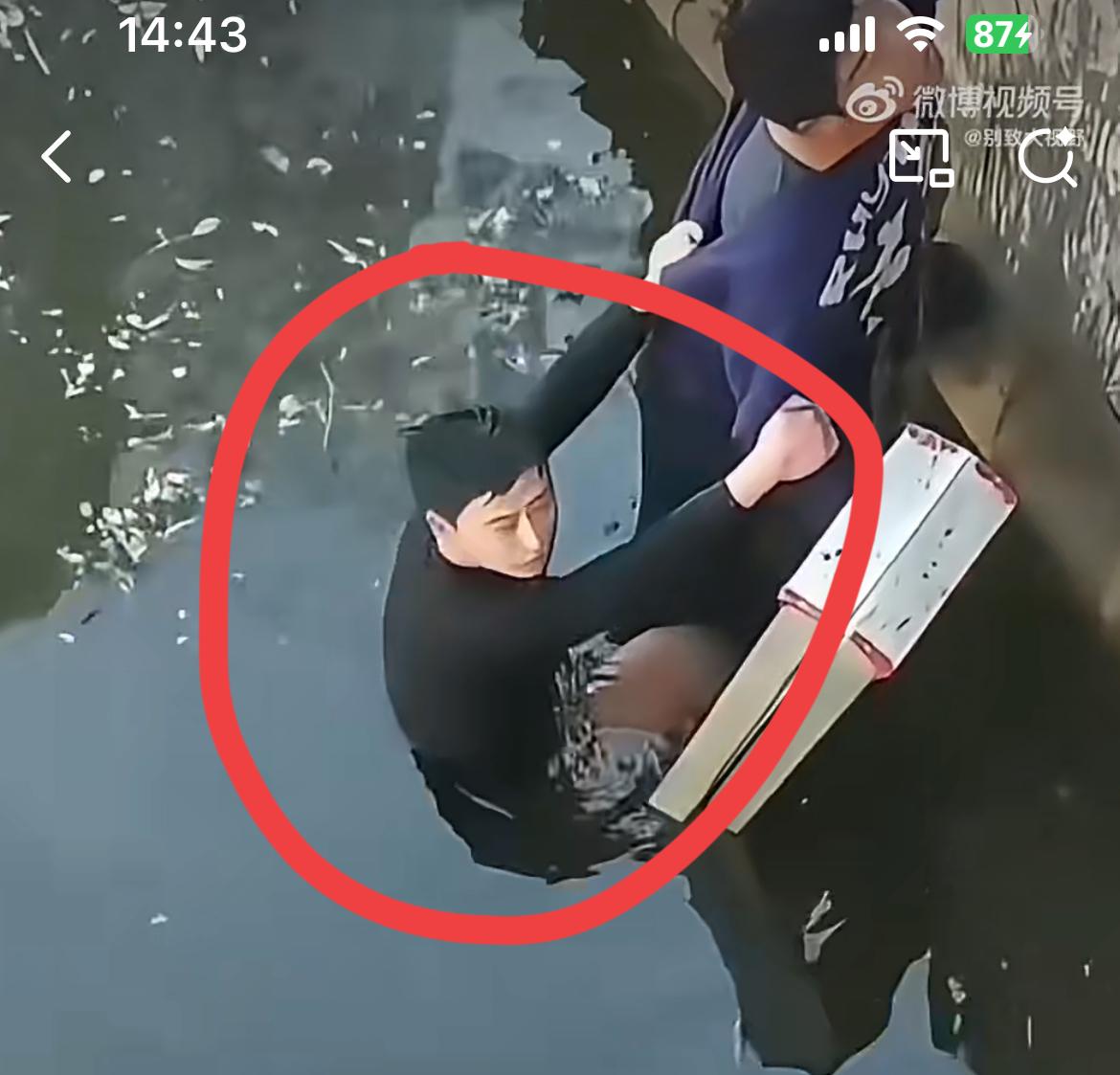 落水救人的荒诞一幕，蓝衣服是救人的大哥，却被被救的黑衣服小伙死命往回拽。黑衣服的