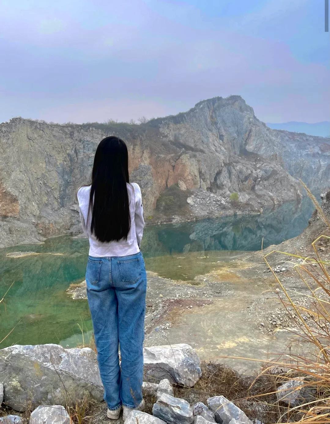 周末寻到一处废弃矿坑，站在崖边望去，岩壁的褶皱里藏着时光的印记，碧绿的水潭像被遗