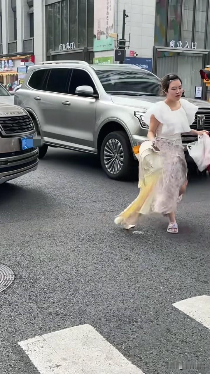 成都一女子“碰瓷”后续，女子将包和行李放在人行道上，然后一个飞身从车前面跳到人行