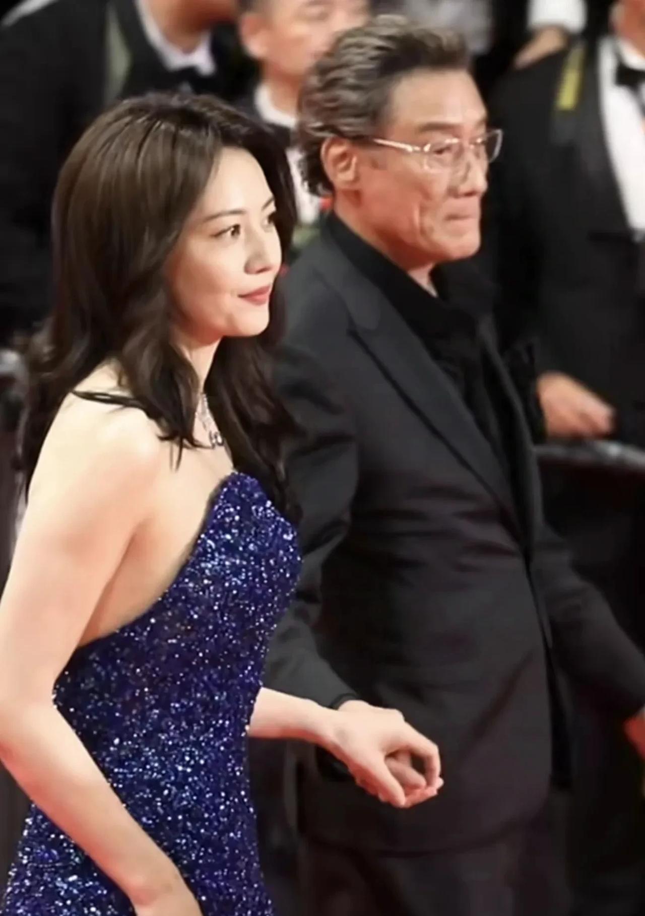 梁家辉如贴心老爸一般俯身为高圆圆整理裙摆，而古天乐则袖手旁观。说到这里不得夸夸