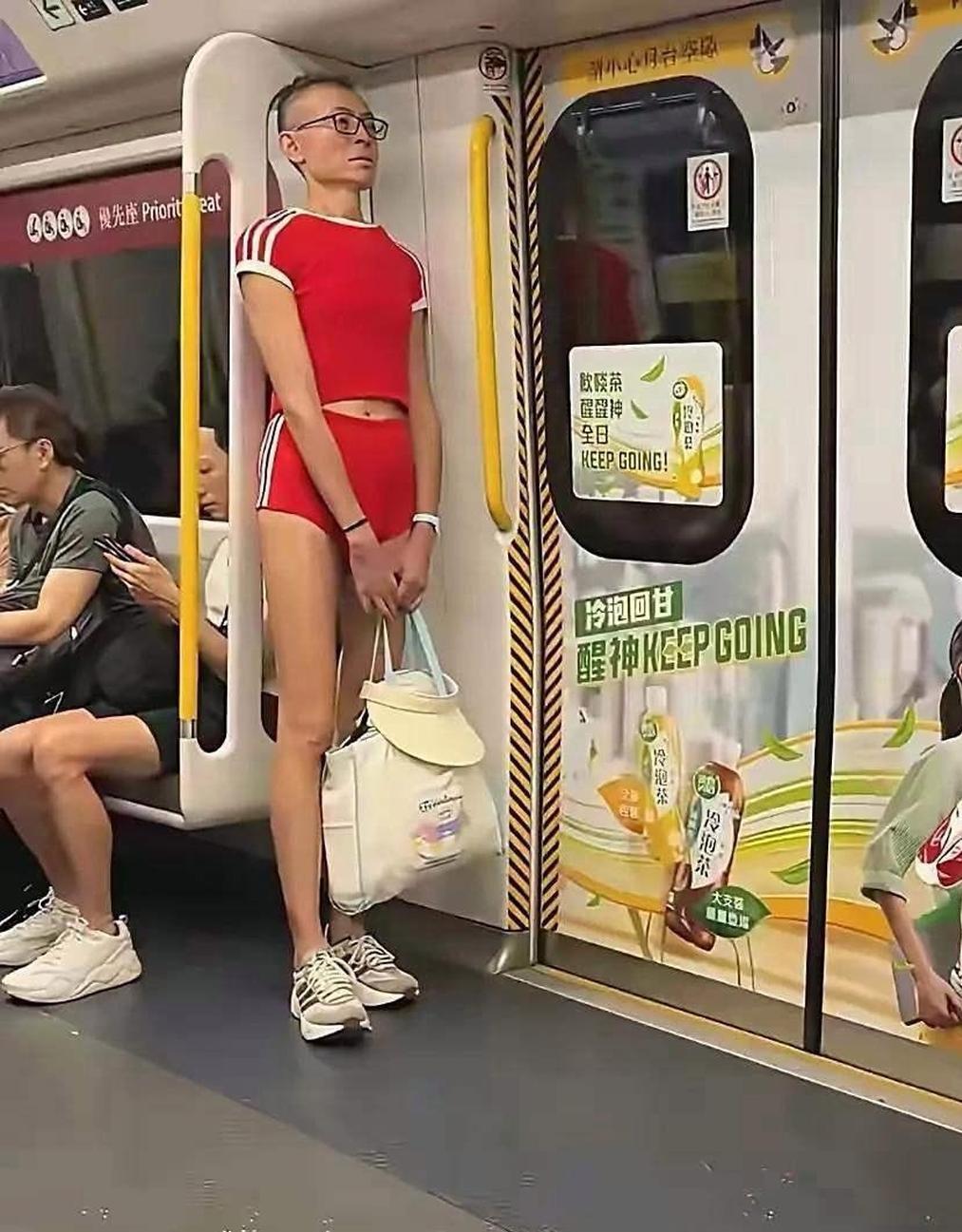 辣眼睛！红衣男穿着好奇葩，中年男人手里拿的是啥呀？图片1，地铁车厢，一位穿着