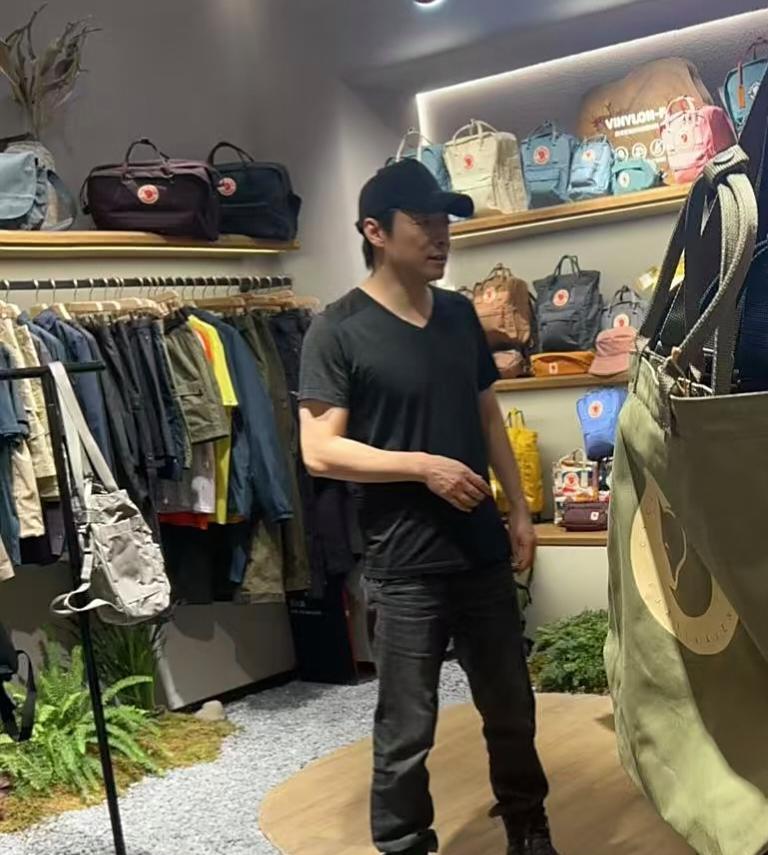 祖峰和老婆刘天池在北京三里屯逛街购物，他穿着一身黑衣，打扮有型，胸肌饱满，身高看