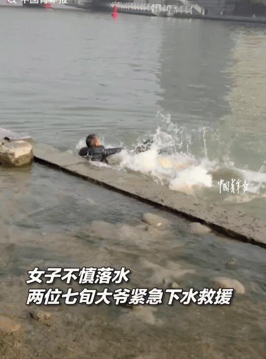 天津，海河边，一个女子不慎落入河中。两个70多岁的大爷赶紧下水。把女子救上来后，