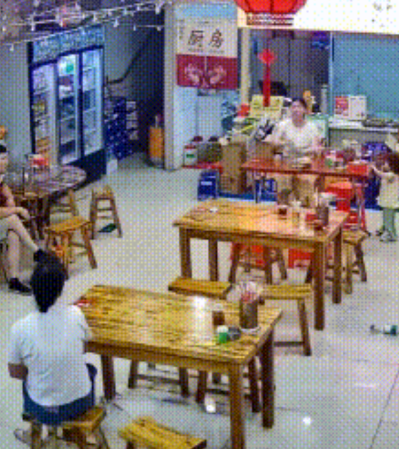 婆媳因小事发生争执，丈夫坐在饭店中间的位置沉默不语，儿媳拍着桌子，指着丈夫说：“