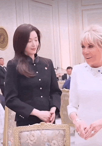 全智贤与布丽吉特同框，她的招牌笑容又出现了，但是很拘谨。感觉法国第一夫人都比她松