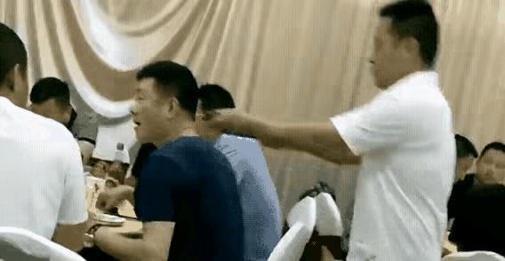 酒席上，一个男人正低头夹菜。身后突然窜出个人，二话不说，一根钢丝锁直接套他脖子上
