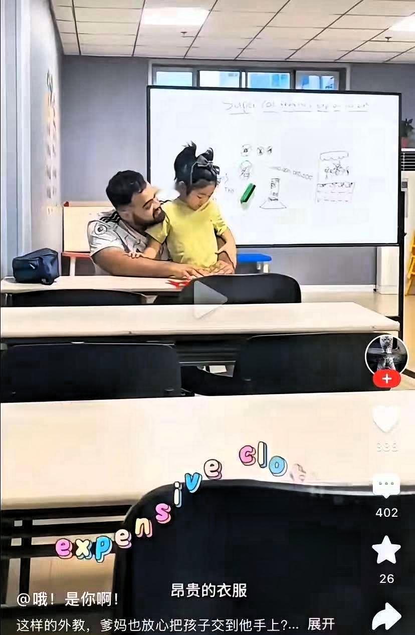 这是一段中国小女孩上外教课的视频：一名男外教将一个小女孩抱在怀里，“亲切”的给孩
