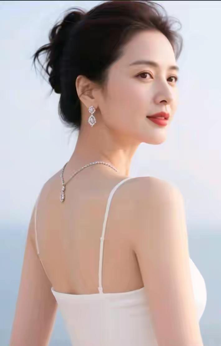 中年女性显娇容，回眸一笑百媚生。出水芙蓉亭亭立，面若桃花抚柳轻。