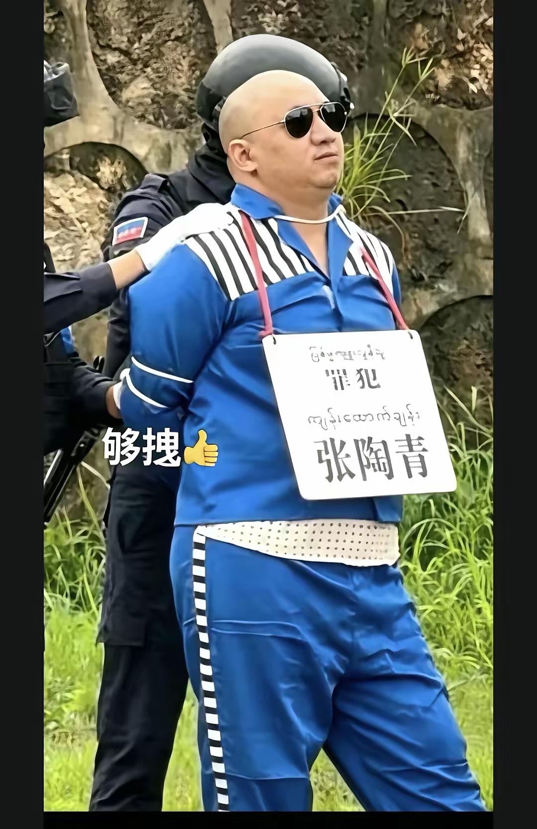 戴着墨镜上刑场，还是第一次见，谁能告诉我这是真的还是假的？罪犯脖子里挂着的牌