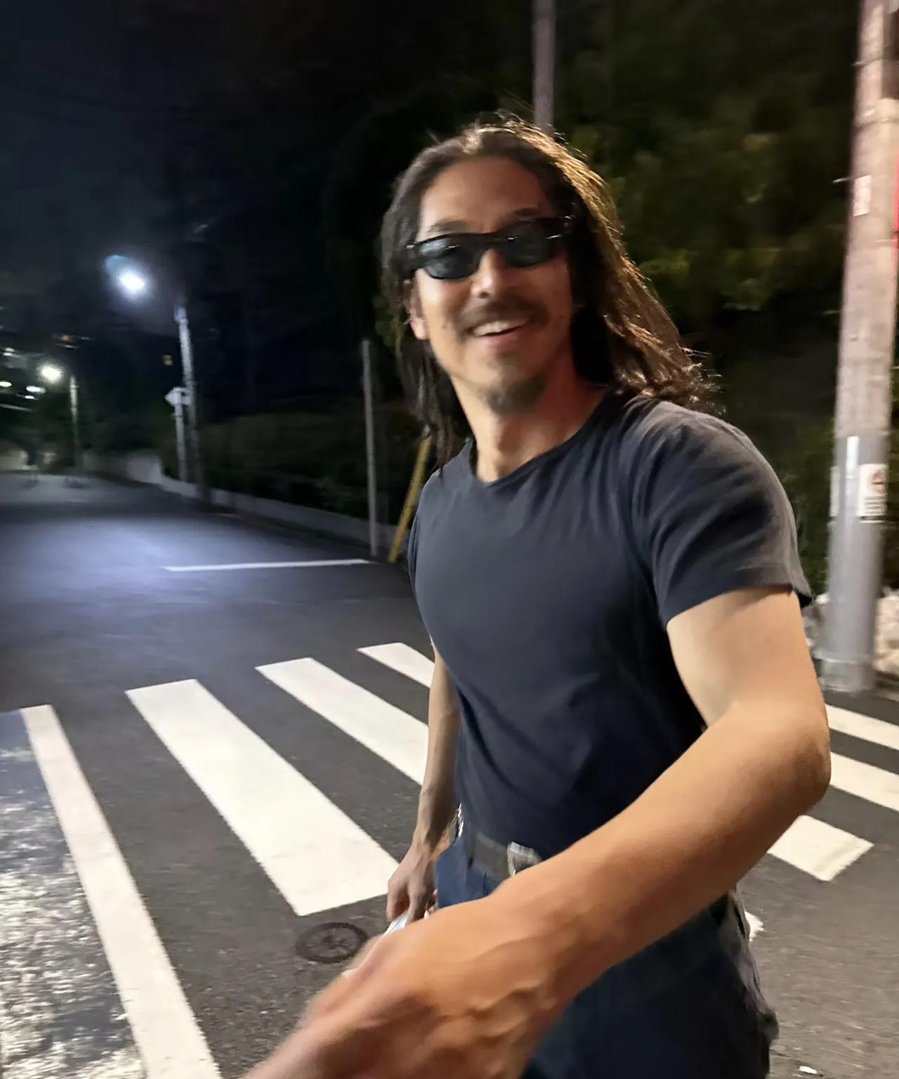 林志玲老公黑泽良平在晚上的街头出现，打扮真的一言难尽，留着一头长发，胡须没刮，不