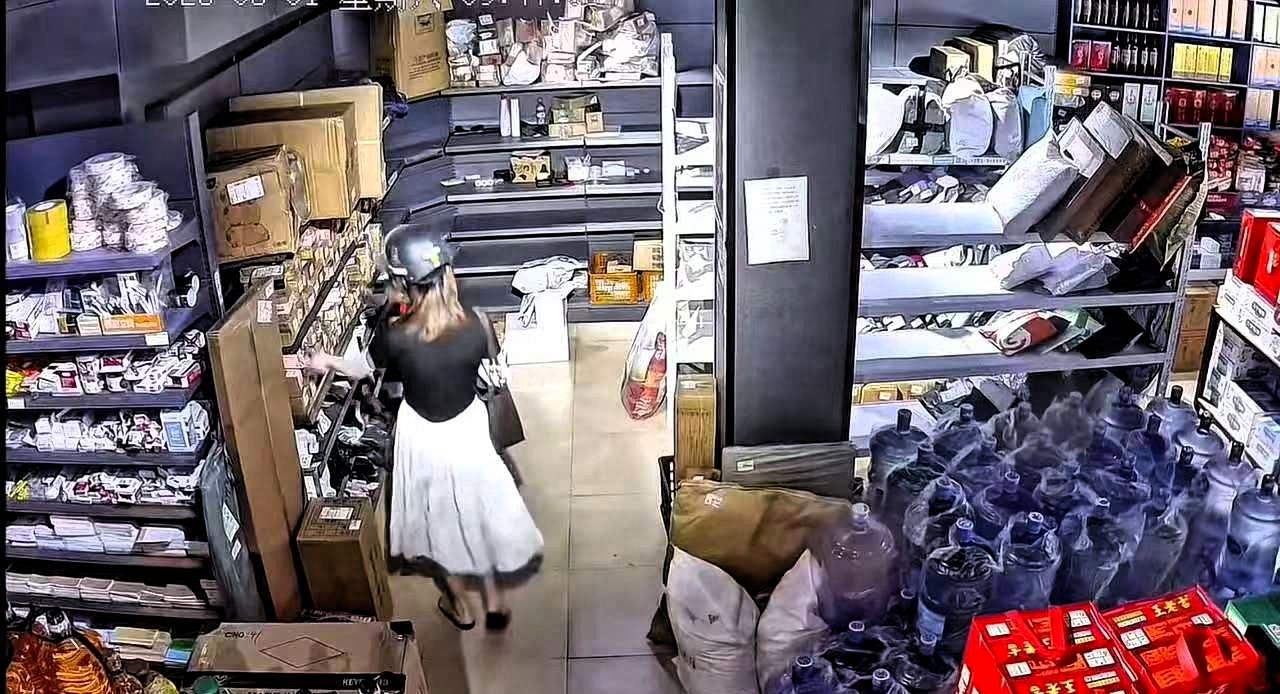 近日广东，一女子戴着头盔、口罩到驿站拿快递，女子进店后，随手就拿起货架上的快递丢