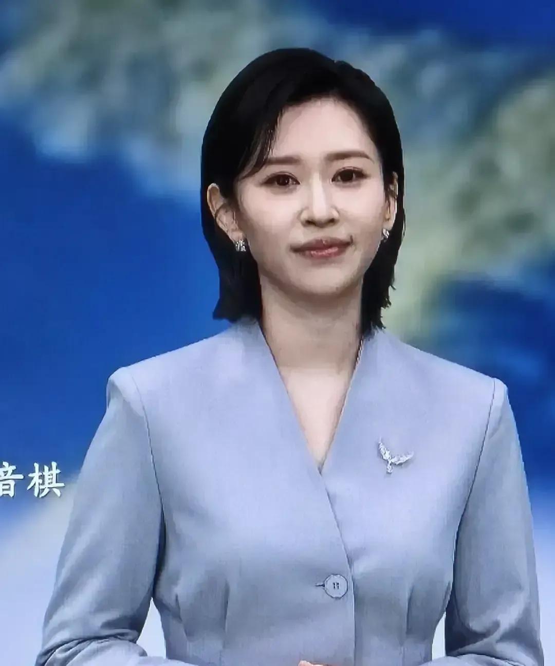 别被《新闻联播》里的她“骗了”。看这张动图：王音棋穿着浅灰中山装，在综艺舞台