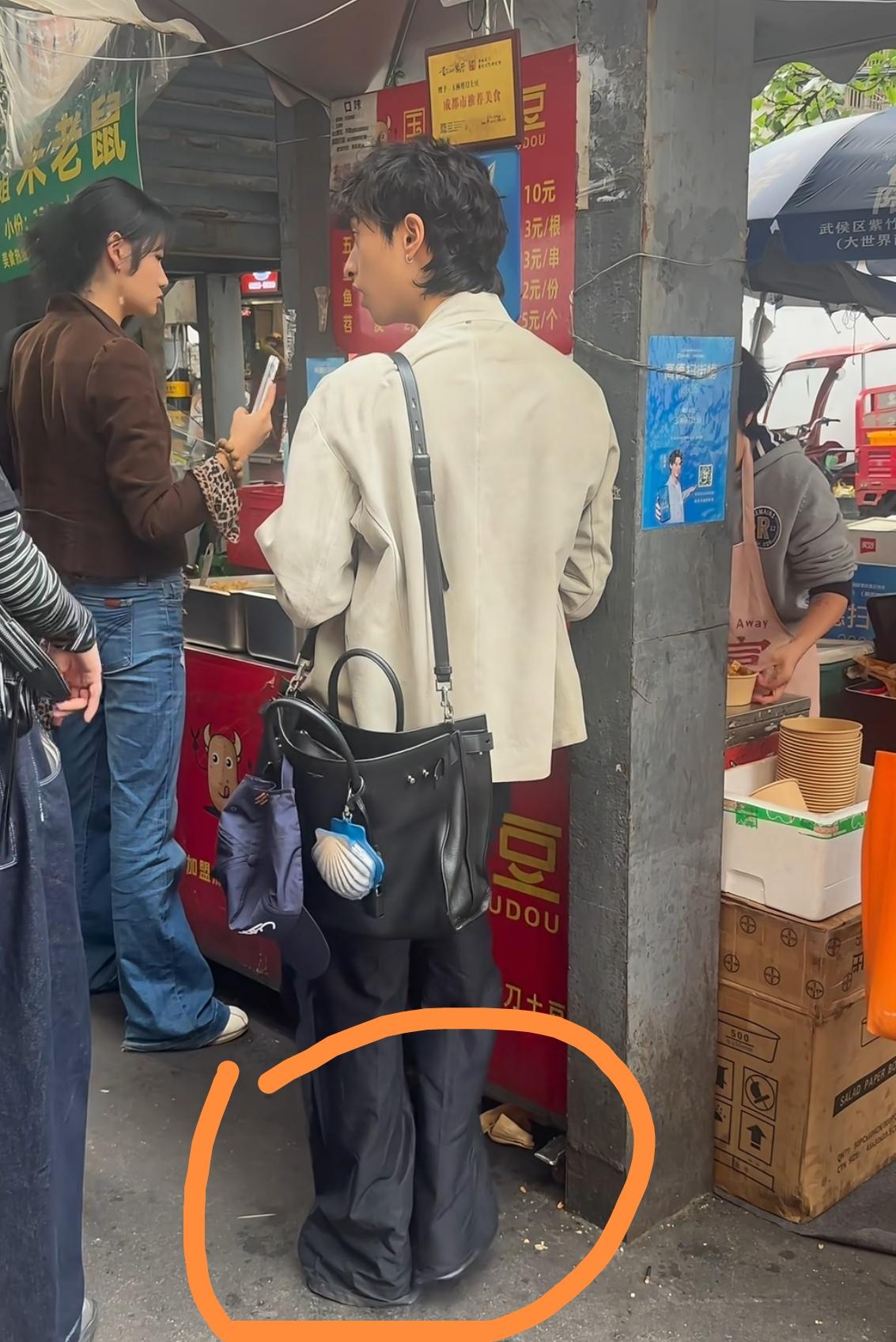 偶遇伊能静的儿子恩利，在路边摊买10元一份的剪刀土豆，他穿着阔腿长裤，由于裤子太
