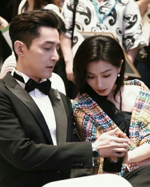 胡歌给万茜看女儿的照片，万茜看的同时还不忘用手挡住，生怕被偷拍。