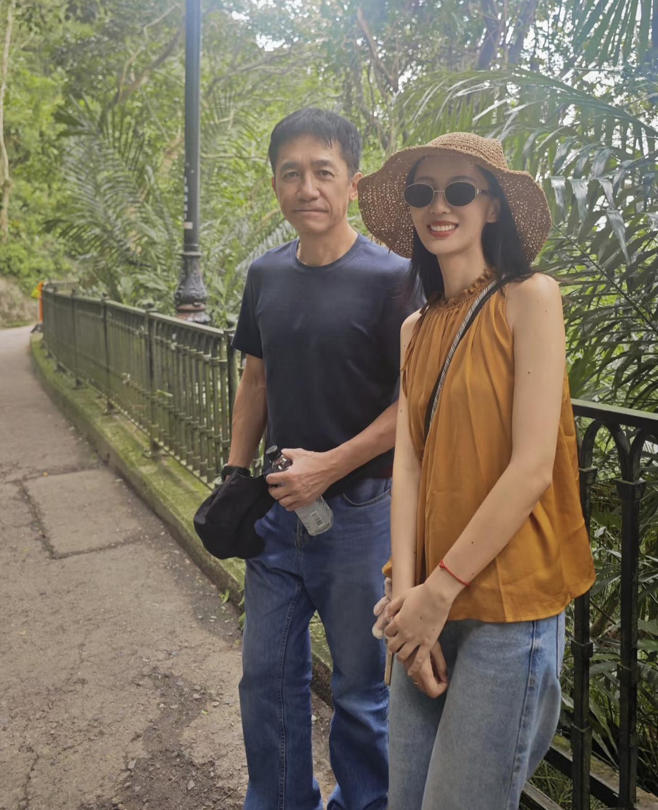 63岁梁朝伟在香港太平山顶被偶遇，他和最近合作的一位外国女导演在欣赏风景，穿着短