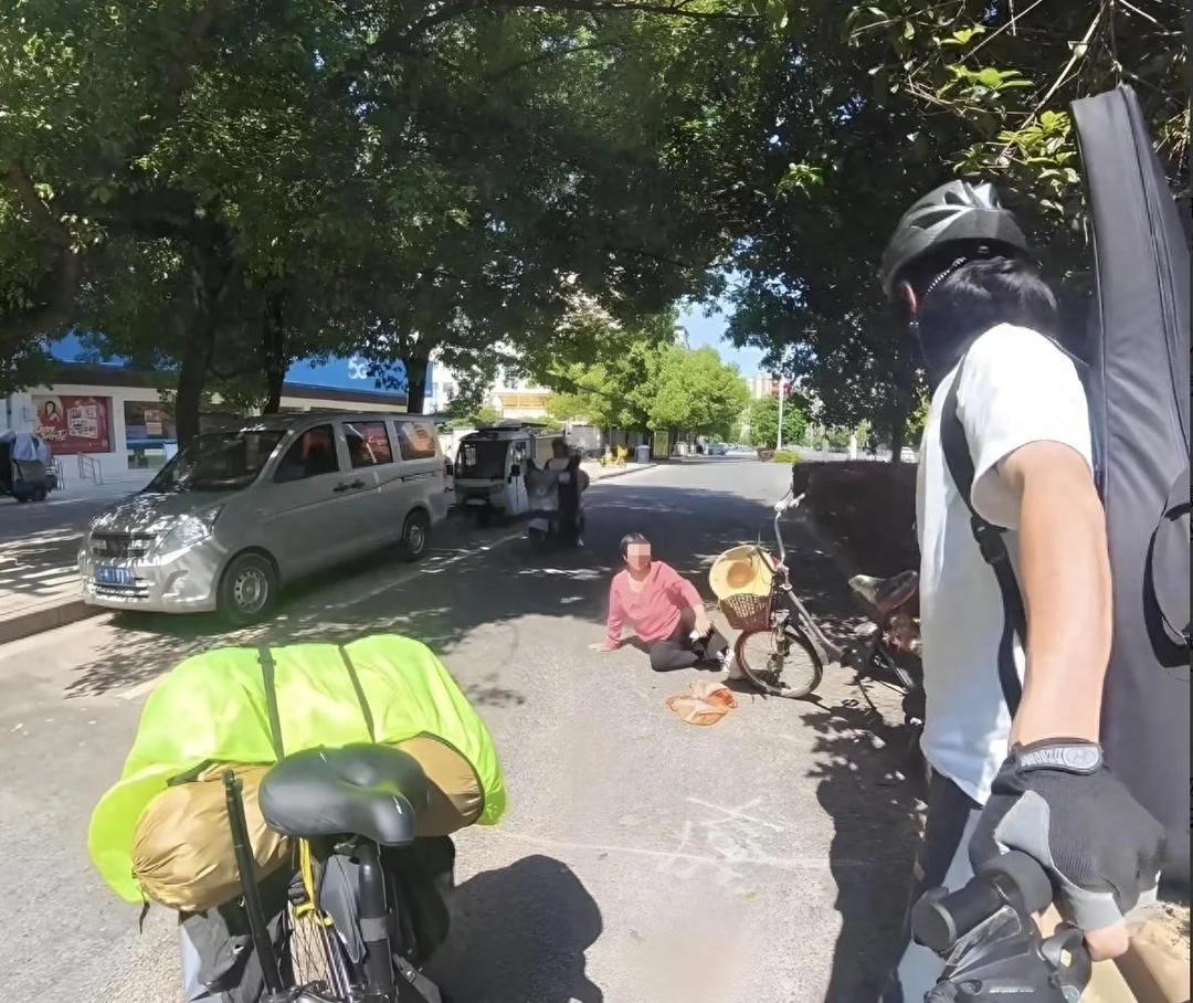 江西抚州。小伙骑着摩托，车头支着手机拍短视频。前方大妈突然摔倒，小伙赶紧去扶，