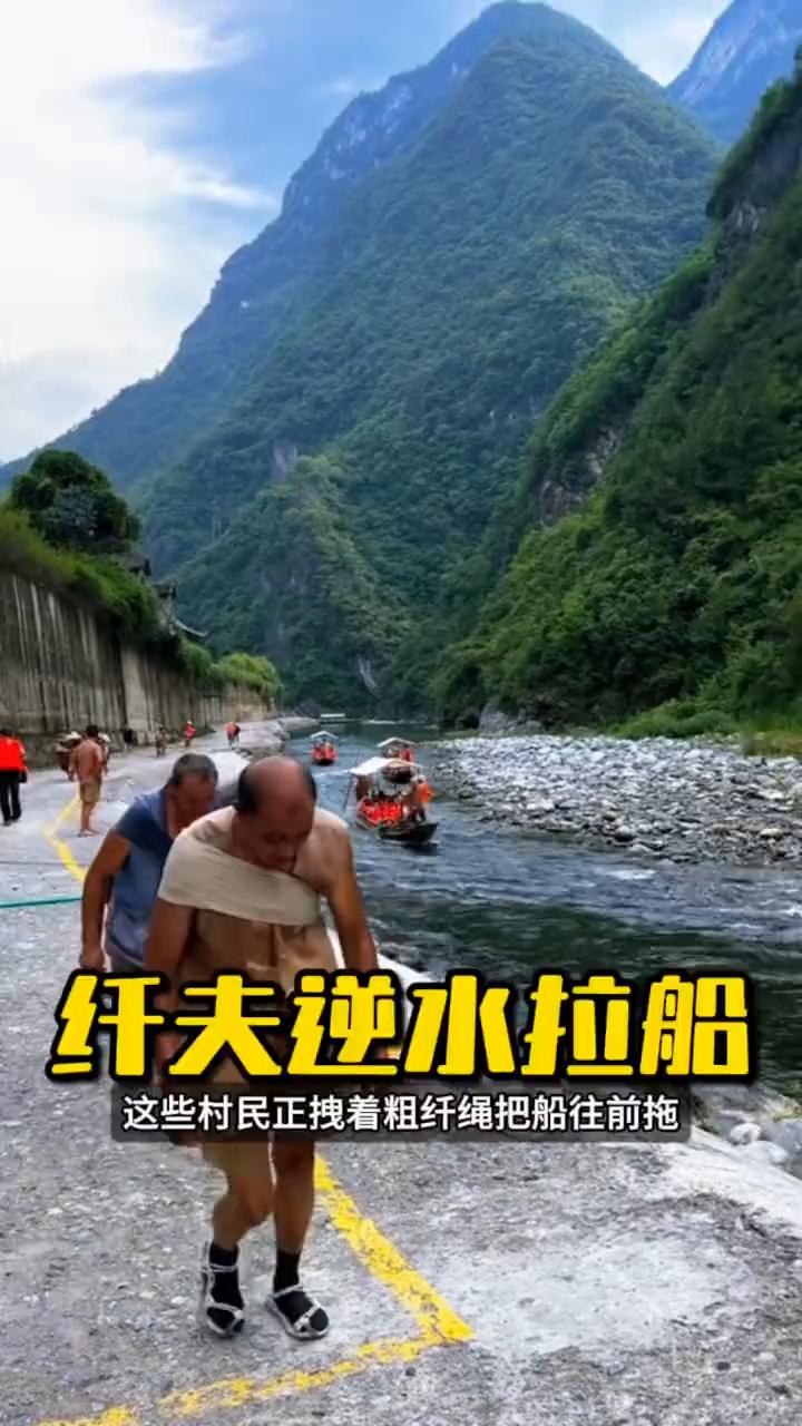 大家注意看，这些村民正拽着粗纤绳把船往前拖，脚下是保底鞋，踩在石头和泥地上几乎没
